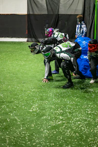 a group of people playing paintball in an indoor arena